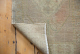 Distressed Oushak rug folded corner, showing hand knotted foundation and intact selvage.
