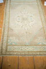 Distressed Oushak rug's softened pile, with ivory, beige, mint, and pale bronze geometric patterns.