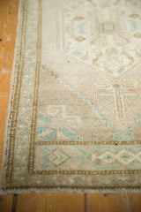 Distressed Oushak rug side selvage with muted beige, mint geometric patterns and worn pile.