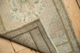 Hand-knotted Oushak rug back, visible dark warp threads, intact selvage, and worn pile.