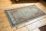 Vintage distressed Oushak rug corner, mint green starburst on pale copper bronze ground.