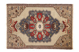 Vintage Oushak rug, large denim blue medallion, cherry red blossoms on ivory-beige ground.