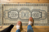 Distressed Oushak rug corner: germinating tree of life motif on antique ivory field.