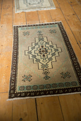 Vintage distressed Oushak rug mat with softened pile, geometric medallion, and mint green accents.