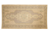 Hand knotted Vintage Distressed Oushak runner with pale slate mauve geometric medallion on antique ivory.