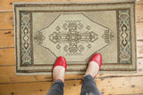 Distressed Oushak rug, lower medallion with stepped perimeter, geometric border in ivory and brown.
