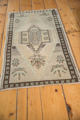 Distressed geometric medallion, serrated outlines, and chocolate brown border on vintage Oushak mat.