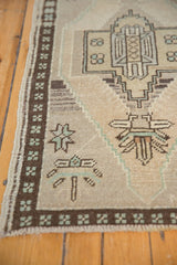 Abrashes and textured pile of a vintage Oushak rug with geometric border and seafoam green patterns.