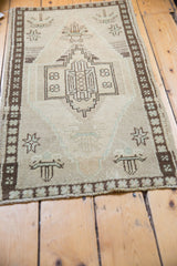 Corner detail of distressed Oushak rug showing geometric border, soft pile, and ivory fringe.