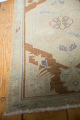 Vintage Oushak rug corner with original selvage, fringe, and distressed ivory bronze pattern.
