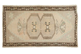 Vintage distressed Oushak rug with geometric double medallions, plant motifs, muted beige, brown, seafoam.