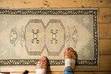 Distressed vintage Oushak rug mat featuring double medallion, germinating plant motifs, and soft colors.