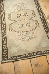 Geometric plant motif and stepped border of distressed Oushak rug with seafoam green.