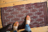 Intricate ivory geometric pattern on dark wine red vintage Turkish Jijim rug.