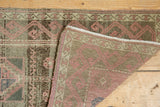 Folded corner of the distressed Oushak rug, showing its hand-knotted back and original selvage.