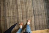 Vintage Moroccan Kilim rug with hand-woven texture and rich brown striped bands.