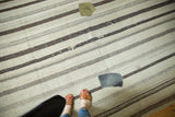 Vintage Turkish Kilim showing natural ivory and brown striped bands with contrasting textile patches.