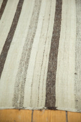 Handwoven vintage Turkish kilim detail, showing varied natural ivory, silver, and brown striped texture.