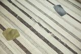 Vintage Turkish Kilim carpet with striped undyed wool texture, worn regions, and grey and olive patches.
