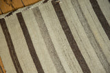 Close-up of hand woven flatweave vintage kilim with natural ivory and varied brown stripes.