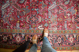 Vintage Heriz carpet's geometric border, brick red field, navy, gold patterns, with mostly low pile.