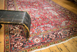 Vintage Heriz carpet with brick red geometric floral patterns, serrated leaves, and low pile.