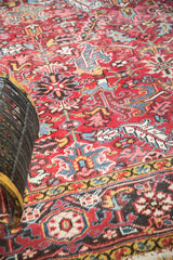 Vintage Heriz rug detail: geometric floral design with brick red and navy tones.