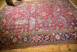 Vintage Heriz carpet detail: geometric floral pattern, brick red field, low pile wear, foundation showing.