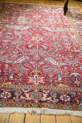 Heriz rug border in navy, ivory, gold geometric motifs, showing low pile and fringe.