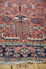 Close-up of vintage Heriz carpet with rectilinear floral motifs, mostly low pile, and ivory fringe.