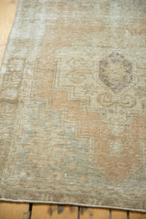 Distressed Oushak runner's pale peach, ivory geometric pattern, and texture with mostly even wear.