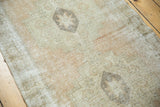 Close-up of distressed texture on vintage Oushak runner, apricot peach and ivory geometric motifs.