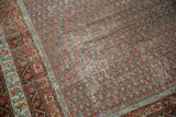 Close-up of distressed vintage Mir Serbend carpet, showing slate blue field, madder red boteh, and textured wear.