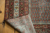 Distressed vintage Mir Serbend rug fold displaying hand-knotted foundation and boteh pattern.