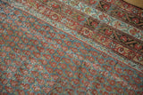 Distressed Mir Serbend carpet close-up: slate blue, madder red boteh pattern, foundation wear visible.
