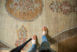 Vintage Oushak carpet section with bronze roundel, blossomed plants, stepped borders, abrashes.