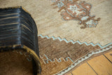 Low pile vintage Oushak rug featuring detailed stepped border and potted blossom motif.