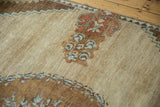 Oushak rug detail: abrash on pale sand field, madder root rust, powder blue potted plant motifs.