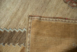Corner of a vintage Oushak rug revealing its hand-knotted back and zig-zag border.