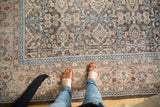 Distressed vintage Sivas carpet: faded charcoal field, pale rose border with teal vinery.