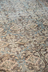 Distressed Sivas rug's worn pile texture, with charcoal, beige, and teal blue floral palmette vinery.
