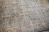 Time-softened floral palmette and vinery on distressed Sivas carpet in charcoal, rose, and dark teal.