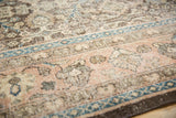 Distressed Sivas carpet with faded rose, brown, and teal floral palmette motifs.