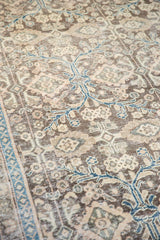 Distressed pile texture with charcoal, beige, and teal blue floral vinery on vintage Sivas carpet.