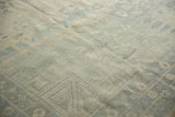 Angled detail of vintage Pakistani Khotan carpet, highlighting soft pale blue and ivory pile.