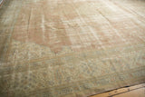 Worn texture of a vintage distressed Sparta rug, showing dusty rose field and ivory patterns.