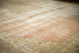 Distressed vintage Sparta rug features dusty rose field and an antique ivory floral border.