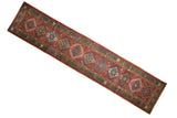 Vintage Persian Karaja runner with repeating diamond medallions in brick red, navy, and green.