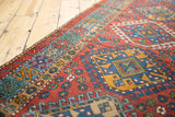 Detailed view of the geometric border and latch-hook medallion on a vintage Karaja runner rug.