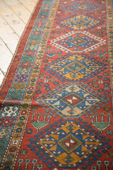 Angled view of the repeating hook and latch medallions on a vintage Persian Karaja runner.